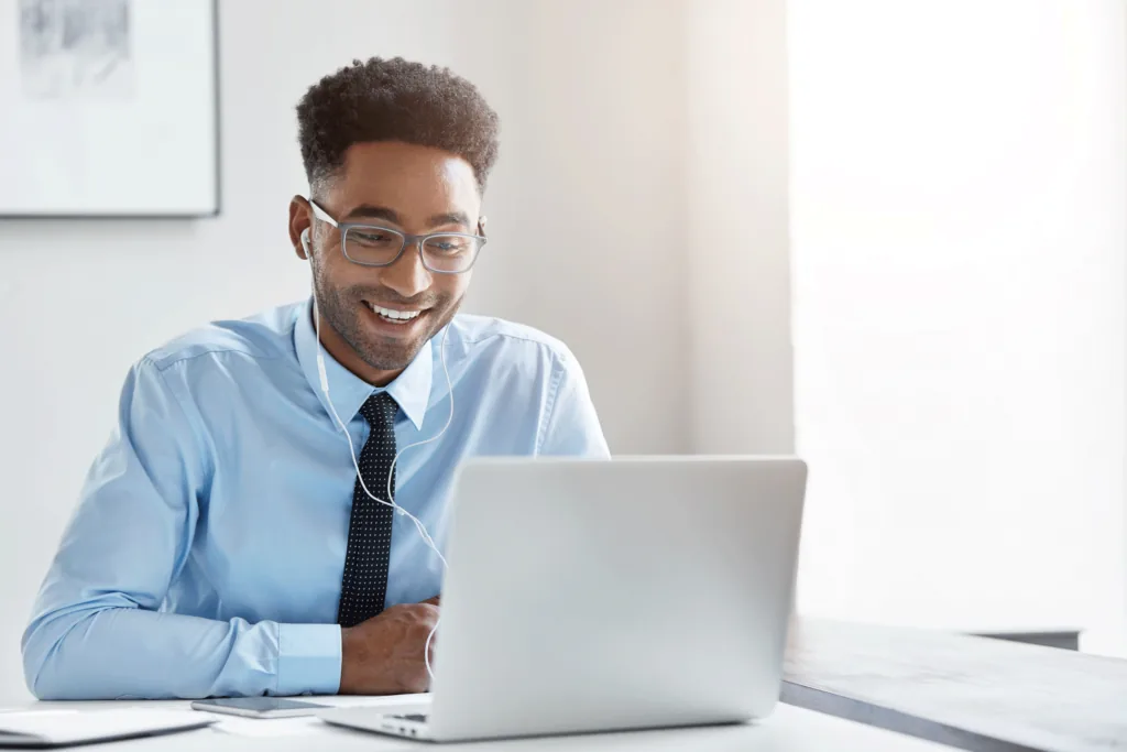 Homem sentado e trabalhando no notebook com fones de ouvido.
